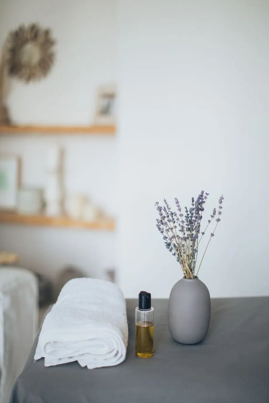 Composición serena de spa con toalla doblada, aceite y lavanda